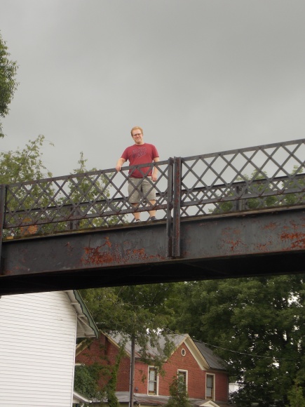Justin reluctantly agreed to take this extra manly photo standing on the passenger bridge over the railroad tracks with the storm clouds looming behind him. We found this spot along the Non-Creeper Trail.